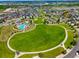 Wide aerial shot of the community featuring a large park, pool area, clubhouse, and residential homes at 17548 Bluetrail Ave, Parker, CO 80134