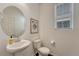 Charming powder room with a pedestal sink, decorative mirror, and a window for natural light at 17548 Bluetrail Ave, Parker, CO 80134