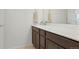 Bathroom vanity with solid surface countertop and a large mirror at 17548 Bluetrail Ave, Parker, CO 80134