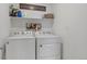 Bright laundry room featuring white washer and dryer with a shelf at 17548 Bluetrail Ave, Parker, CO 80134