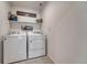 Functional laundry room with a side-by-side washer and dryer, shelving, and minimalist decor at 17548 Bluetrail Ave, Parker, CO 80134