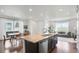 Bright, open-concept living space combining the kitchen, dining, and living areas with hardwood floors and lots of natural light at 17548 Bluetrail Ave, Parker, CO 80134