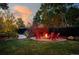 Fire pit surrounded by red chairs in a beautifully landscaped backyard at 5123 Bryant St, Denver, CO 80221