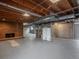 Basement with exposed beams, brick fireplace and concrete walls at 5361 Nassau Cir, Cherry Hills Village, CO 80113