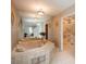 Bathroom featuring tiled walls, glass block decor, and a large tub with gold fixtures at 5361 Nassau Cir, Cherry Hills Village, CO 80113