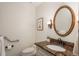 Cozy powder room with decorative mirror, stylish sconce lighting, and granite countertop at 5361 Nassau Cir, Cherry Hills Village, CO 80113