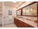Bathroom featuring a double vanity, framed mirrors, and stylish gold fixtures at 5361 Nassau Cir, Cherry Hills Village, CO 80113