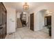 Bright foyer with tile flooring, chandelier lighting, staircase to the second floor, and arched doorway at 5361 Nassau Cir, Cherry Hills Village, CO 80113