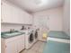 Bright laundry room features a washer, dryer, wash basin, and countertop at 5361 Nassau Cir, Cherry Hills Village, CO 80113