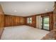 Living room with wood paneling, a stone fireplace, and sliding glass doors at 5361 Nassau Cir, Cherry Hills Village, CO 80113
