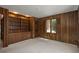 Inviting living room with wood paneling, built-in bookcase and window allowing natural light at 5361 Nassau Cir, Cherry Hills Village, CO 80113