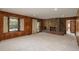 Living room with a stone fireplace, wood paneling, and large windows at 5361 Nassau Cir, Cherry Hills Village, CO 80113