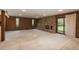 Large living room features a stone fireplace, wood-paneled accent wall, carpet, and a sliding glass door at 5361 Nassau Cir, Cherry Hills Village, CO 80113