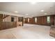 Expansive living room with wood-paneled walls, plush carpet, and a view of the stairs to the upper level at 5361 Nassau Cir, Cherry Hills Village, CO 80113
