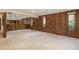 Spacious living room features wood paneling, mirrored wall, neutral carpet and natural light from the window at 5361 Nassau Cir, Cherry Hills Village, CO 80113