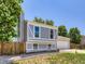 Charming two-story home with gray and white paint, wood fence, and well-maintained lawn at 1956 Cathay St, Aurora, CO 80011