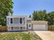 Charming two-story home with gray and white paint, two car garage, and well-maintained lawn at 1956 Cathay St, Aurora, CO 80011