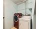 Laundry room featuring newer red washer and older white dryer appliances at 1956 Cathay St, Aurora, CO 80011