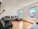 Living room features hardwood floors, two windows, a sectional sofa, and a futon at 1956 Cathay St, Aurora, CO 80011