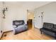 Living room featuring a hardwood floor, a large chair, and an adjacent dining area at 1956 Cathay St, Aurora, CO 80011