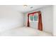 Bright bedroom features neutral carpet and a window with curtains for natural light at 7641 Kelty Trl, Franktown, CO 80116