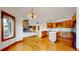 Spacious kitchen with wood cabinets, hardwood floors, a center island and stone fireplace at 7641 Kelty Trl, Franktown, CO 80116