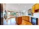 A kitchen features wood cabinets, hardwood floors, a center island and stone fireplace at 7641 Kelty Trl, Franktown, CO 80116