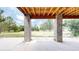 Concrete patio featuring a wood ceiling and brick pillars, surrounded by greenery at 7641 Kelty Trl, Franktown, CO 80116