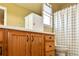 Bathroom with a wooden vanity, a tile countertop, and a checkered shower curtain at 1168 Coneflower Way, Brighton, CO 80601