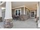 Inviting covered front patio with seating area, stone accents, and stylish curb appeal at 1168 Coneflower Way, Brighton, CO 80601