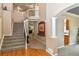 Elegant foyer features a staircase with iron railings, hardwood floors, and natural light at 1168 Coneflower Way, Brighton, CO 80601