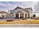 Charming two-story home featuring a covered front porch, three-car garage, and landscaped front yard at 1168 Coneflower Way, Brighton, CO 80601