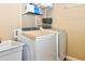 Efficient laundry room featuring a front-load washer and dryer, shelving and a utility sink, providing functionality and organization at 1168 Coneflower Way, Brighton, CO 80601