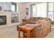 Comfortable living room with a fireplace, built-in TV, and a cozy brown sectional sofa with a window that has natural light at 1168 Coneflower Way, Brighton, CO 80601