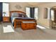 Inviting primary bedroom with neutral tones, large windows, a decorative headboard, and cozy furniture on carpet flooring at 1168 Coneflower Way, Brighton, CO 80601