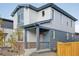 Two-story house with gray and white siding, a red door, and a small front porch at 21021 E 63Rd Dr, Aurora, CO 80019