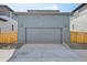 Gray detached garage with a large door and exterior lighting at 21021 E 63Rd Dr, Aurora, CO 80019