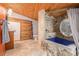 Bathroom with stone shower, soaking tub, and wood details at 30174 Glen Eyrie Dr, Evergreen, CO 80439