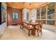 Rustic dining area with a large wooden table, wood floors, and a stone accent wall at 30174 Glen Eyrie Dr, Evergreen, CO 80439