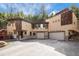 A contemporary two-story home nestled in a wooded setting, featuring a large driveway and attached two-car garage at 30174 Glen Eyrie Dr, Evergreen, CO 80439