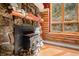 Stone fireplace with wood mantle and wood stove, adding rustic charm at 30174 Glen Eyrie Dr, Evergreen, CO 80439