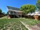 Backyard featuring a spacious deck, green lawn, established tree, and sturdy wood fencing at 4824 S Eaton Park Way, Aurora, CO 80016