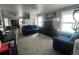 Living room featuring blue couches, a TV, carpet, and two windows at 4824 S Eaton Park Way, Aurora, CO 80016