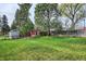 Large backyard featuring storage shed, privacy fence, mature trees, and spacious lawn at 6587 S Clarkson St, Centennial, CO 80121