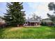Expansive backyard featuring a lush lawn, mature trees, a covered patio, and full privacy fence at 6587 S Clarkson St, Centennial, CO 80121