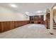 Spacious finished basement with wood paneling, built-in shelving and staircase at 6587 S Clarkson St, Centennial, CO 80121