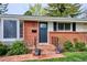 Close-up of the home's entrance, showing a brick facade, quaint porch, and vibrant flower pots at 6587 S Clarkson St, Centennial, CO 80121