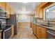 Updated kitchen with stainless steel appliances, custom cabinets, and adjacent eat-in kitchen nook at 6587 S Clarkson St, Centennial, CO 80121