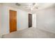 A bedroom with carpeted floors, ceiling fan, two doors and a view from a window at 3065 Zion St, Aurora, CO 80011