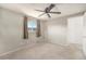 A bedroom with carpeted floors, a ceiling fan, and a view from a window at 3065 Zion St, Aurora, CO 80011